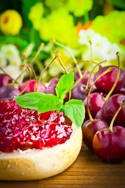 Delicious roll with cherry jam and fresh fruits for breakfast — Stock Photo, Image