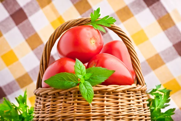 Cesta de mimbre llena de tomates frescos y tomates cherry —  Fotos de Stock