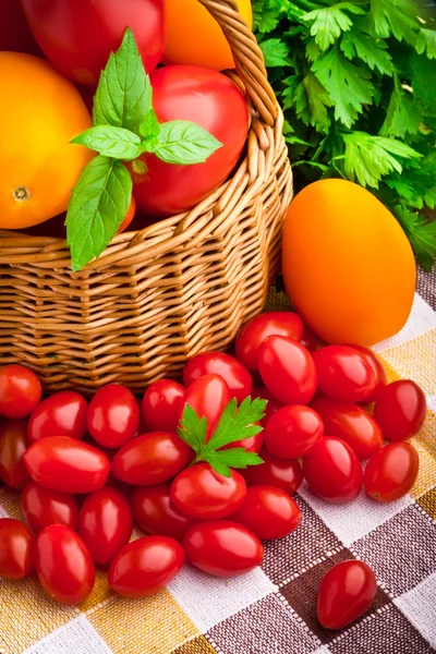 Rieten mand vol met verse tomaten en cherry tomaten — Stockfoto