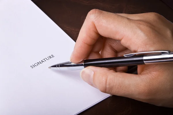 Mão humana com caneta assinando um documento — Fotografia de Stock