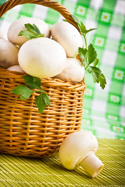 Rieten mand vol met verse champignon paddestoelen — Stockfoto