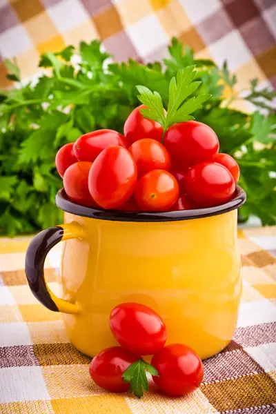 Caneca amarela cheia de tomates cereja frescos — Fotografia de Stock