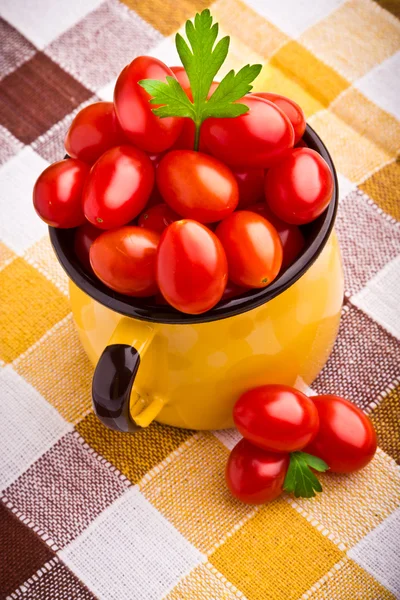 Taza amarilla llena de tomates cherry frescos —  Fotos de Stock