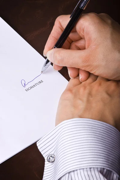 Mänskliga handen med pennan underteckna ett dokument — Stockfoto