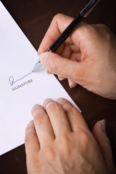 Mão humana com caneta assinando um documento — Fotografia de Stock