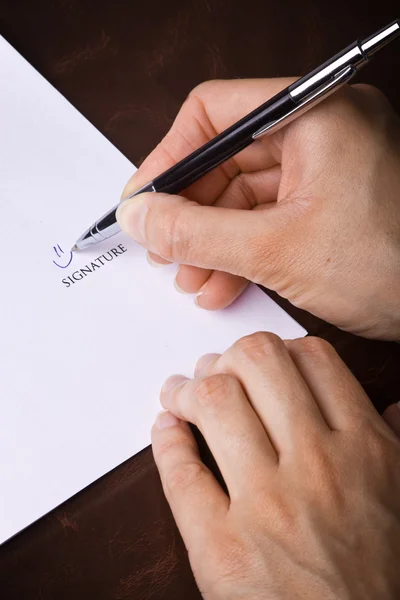 Mão humana com caneta assinando um documento — Fotografia de Stock