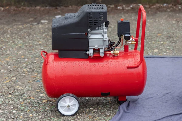 Small Red Air Compressor Rain Wet — стокове фото