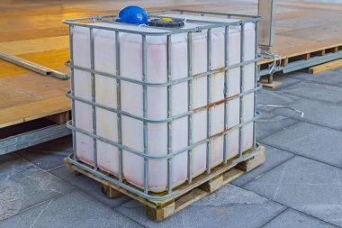 Portable Water Storage Tank Cage Pallet at Construction Site clipart