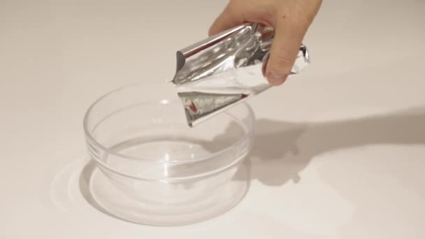 Men Pouring Oatmeal Mylar Bag Glass Bowl — Vídeo de Stock