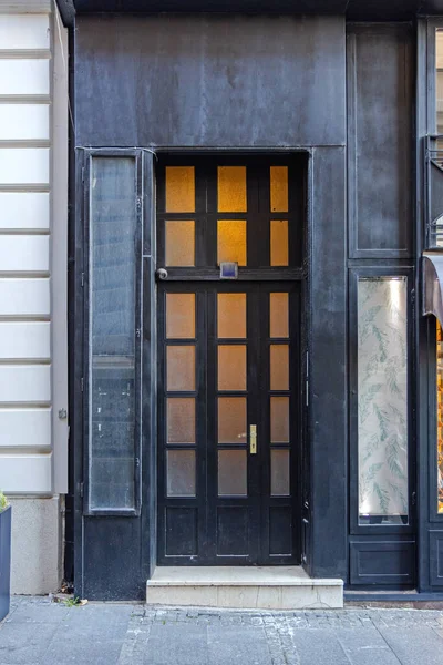 ガラスの建物の通りの入り口と大きな黒いドア — ストック写真