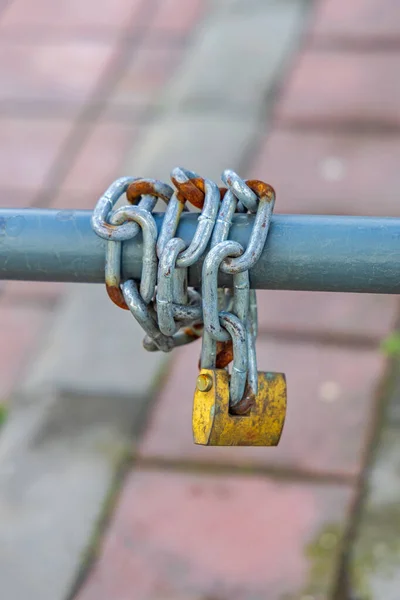 横フェンスポールの周り真鍮南京錠付きチェーン — ストック写真