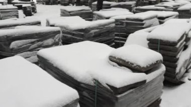 Kış mevsiminde karlı inşaat sahalarıyla kaplı paletler.