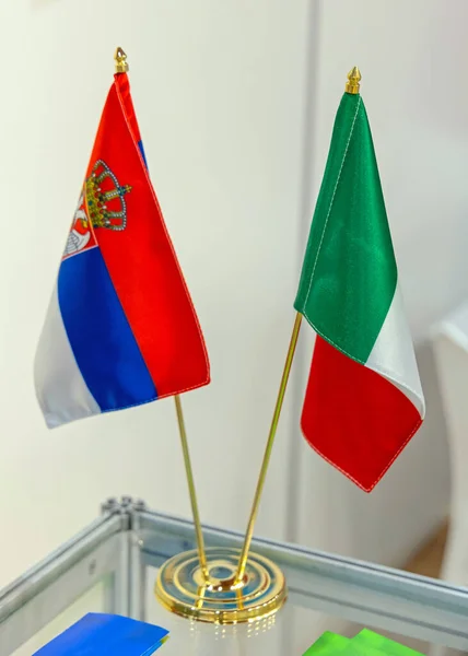 Små Serbiska Och Italienska Flaggor Tillsammans Hållare Vid Bordet Top — Stockfoto