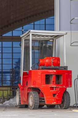 Salondaki küçük kırmızı gaz motorlu forklift.