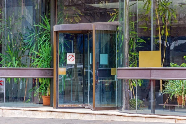 Revolving Doors at Glass Building With Live Green Plants