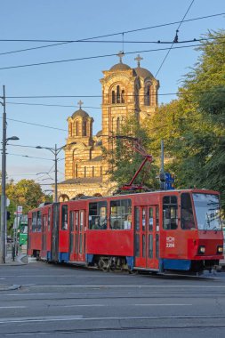 Belgrad, Sırbistan - 01 Ekim 2021: Saint Marko Ortodoks Kilisesi önünde Kızıl Tramvay Toplu Taşımacılığı.