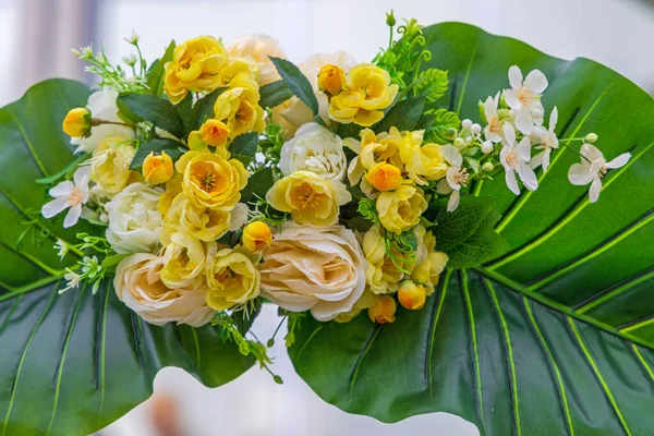 大きな葉の結婚式のアレンジメントの装飾が施された白と黄色の花 — ストック写真