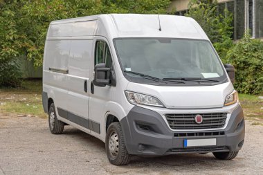 Park yerindeki büyük beyaz kargo minibüs teslimat aracı.