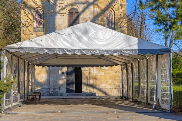 White Canopy Tent Structure in Front of Church Entrance