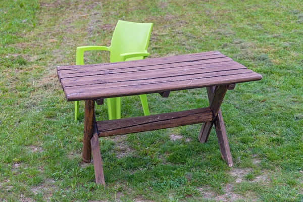 在绿草公园有一张椅子的木制野餐桌 — 图库照片
