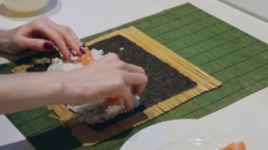 Çiğ somon balığını suşi pilavlı ev yapımı Japon mutfağına koymak.