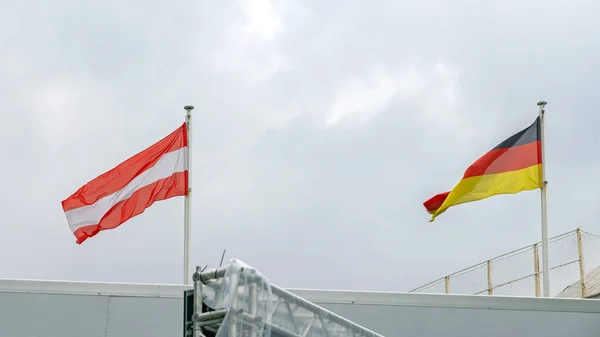 Δημοκρατία Της Γερμανίας Και Αυστρία Σημαίες Μαζί Στον Ουρανό Νεφών — Φωτογραφία Αρχείου