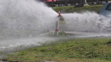 Kırık itfaiye vanası, geçen arabalara su püskürtüyor. Yakınlaştır.