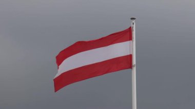 National Flag of Austria at Dark Sky Clouds