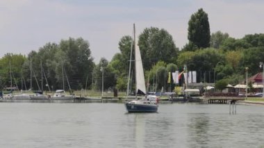 Palic, Serbia - August 01, 2022: Small Sailboat at Calm Water of Palic Lake Nature Park Hot Summer Day.