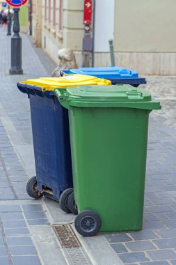Sorting Waste Three Colour Coded Wheelie Bins at Street