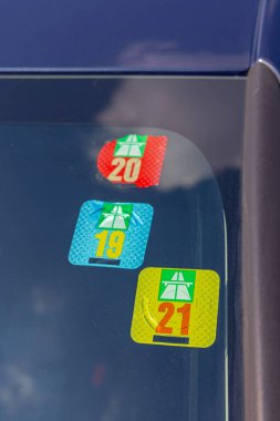 Bern, İsviçre - 25 Ağustos 2022: Car Windshield 'da üç İsviçre Yol Vergisi Etiketi.
