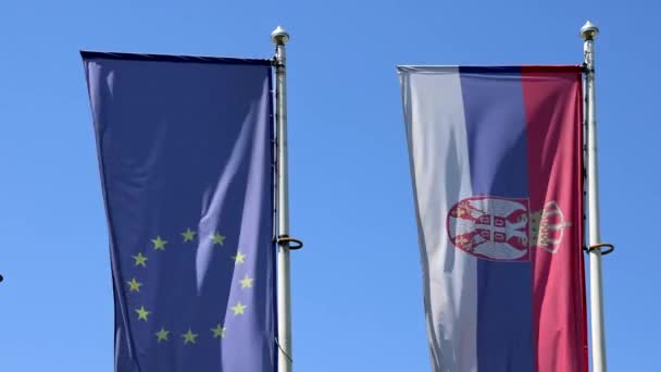 Ευρωπαϊκή Ένωση Και Σερβικές Σημαίες Μαζί Στην Ανεμοδαρμένη Ηλιόλουστη Μέρα — Αρχείο Βίντεο