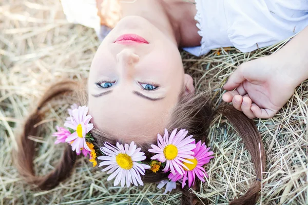 Niña con corona de flores al aire libre — Foto de Stock