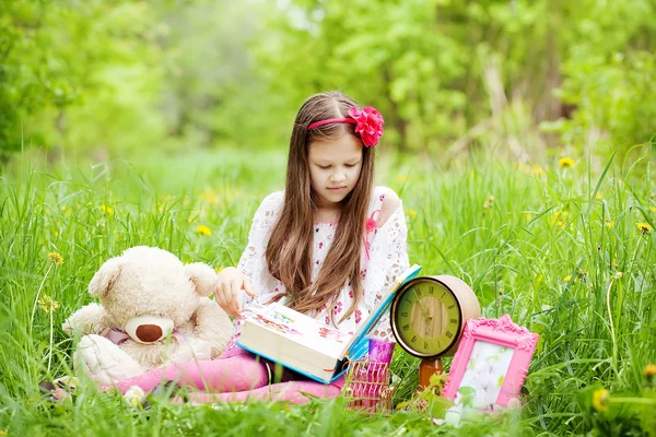 Flickan läser en bok. — Stockfoto