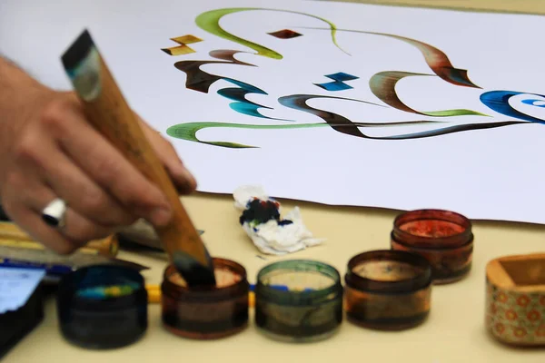 An calligraphy artist and his Arabic writings.