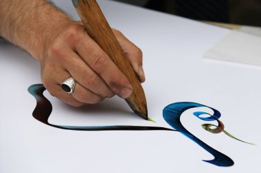 Hammana, Lübnan - 6 Haziran 2017: Festivalde renkli Arapça yazı yazan bir sanatçı.