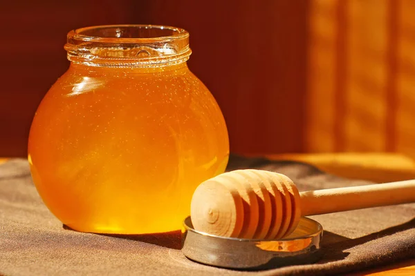 Tarro de vidrio con miel y palo de madera — Foto de Stock