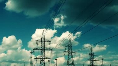 Electric high voltage pylon against sky, time lapse