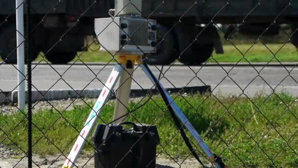 Cámara de velocidad a un lado de la carretera con coches borrosos pasando — Vídeos de Stock