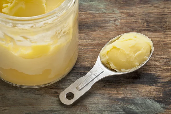 Ghee in jar and spoon — Stock Photo, Image