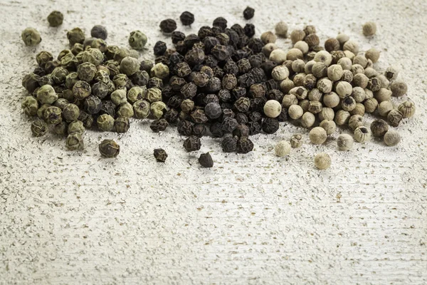 Green, black and white peppercorns — Stock Photo, Image