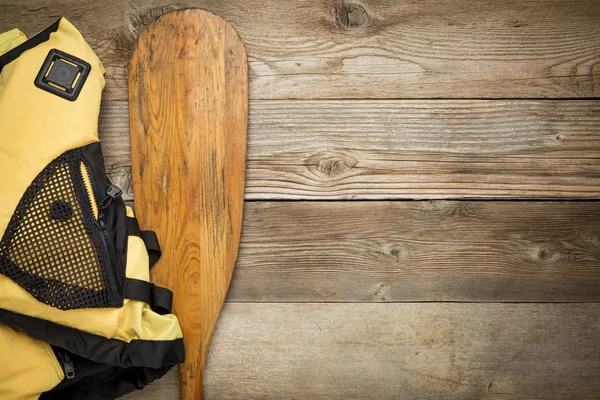 Canoe paddle and life jacket — Stock Photo, Image