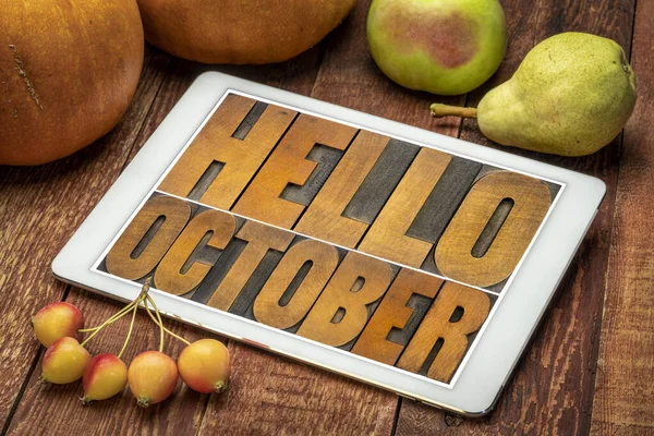 Merhaba October. Kabak ve meyveli dijital tablet ekranında eski harf harfleriyle yazılmış soyut tahta bloklar.