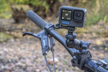 Fort Collins, CO, ABD - 15 Ekim 2021: GoPro Hero 10 siyah, su geçirmez kamera, nehir manzarasına karşı dağ bisikleti gidonu üzerinde popüler eklemli RAM montajı.