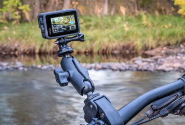 Fort Collins, CO, ABD - 15 Ekim 2021: GoPro Hero 10 siyah, su geçirmez kamera, nehir manzarasına karşı dağ bisikleti gidonu üzerinde popüler eklemli RAM montajı.