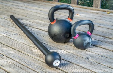 Çelik biber gazı (veya macebell) ve ahşap bir güvertede demir çaydanlık çanları, alışılmadık ekipmanlar kullanarak fitness konsepti