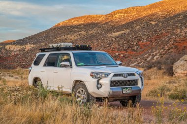 Fort Collins, CO, ABD - 20 Ekim 2021: Toyota 4Runner SUV (2016 Trail Edition), Red Mountain Open Space 'de gün batımında, Colorado eteklerinin sonbahar manzarası.