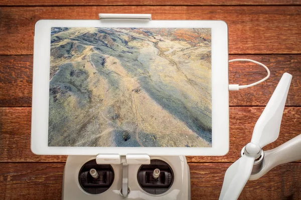 コロラド州北部のロッキー山脈の麓にあり ドローン無線コントローラに搭載されたデジタルタブレット上の航空画像をレビューするトレイルとパスを備えています — ストック写真