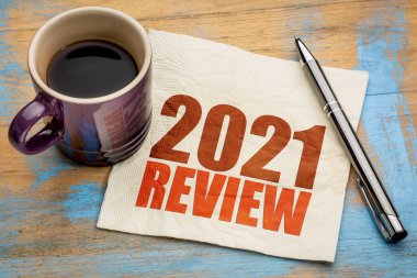 2021 yıllık inceleme metni bir fincan kahveyle birlikte bir peçetenin üzerinde, yıl sonu iş konsepti