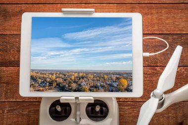 Fort Collins 'in kuzey Colorado' daki yerleşim bölgesinde sonbahar manzarası gündoğumunda, bir İHA radyo kontrolörüne monte edilmiş dijital tablet üzerindeki hava görüntüsünü gözden geçiriyoruz.